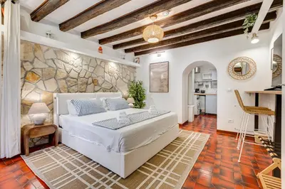 a bedroom with a bed and a stone wall at Colosseum Loft, Rustic-modern charm in Rome