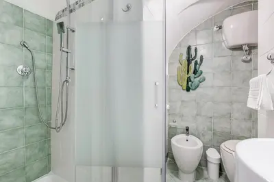 a bathroom with a shower and a toilet and a sink at Colosseum Loft, Rustic-modern charm in Rome
