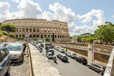 a traffic jam in front of the coliseum at Colosseum 1 Min Design Apt with Private Courtyard in Rome