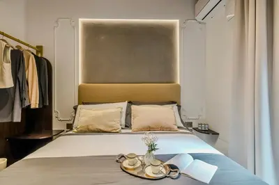 a bedroom with a bed with a large headboard at Colosseum 1 Min Design Apt with Private Courtyard in Rome