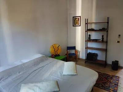 a bedroom with a white bed and a chair at GattaGuest in Rome
