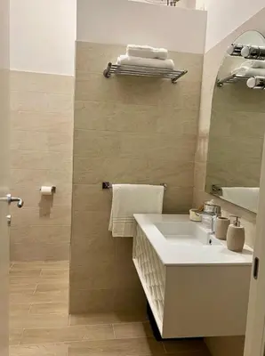 a bathroom with a white sink and a mirror at Manrique home in Rome