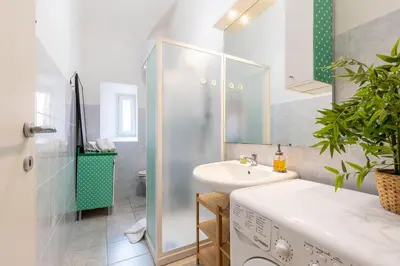 a bathroom with a sink and a washing machine at Rome centre Vatican cozy apartment in Rome