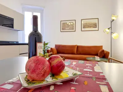 two pomegranates on a plate on a table with a wine bottle at Merulana 13 in Rome