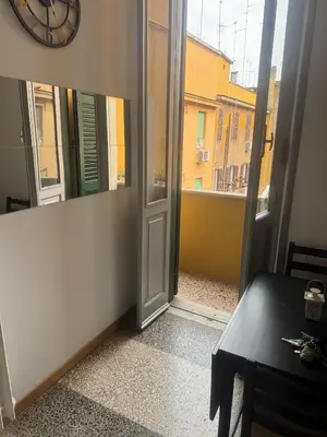 an open door to a balcony with a clock at Cozy Home Flaminio in Rome