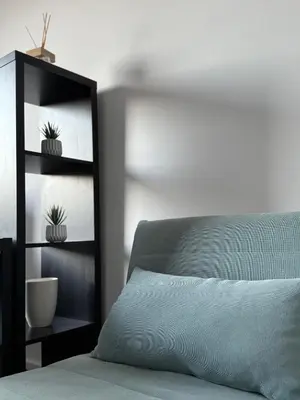 a bedroom with a bed and a shelf with potted plants at Cozy Home Flaminio in Rome