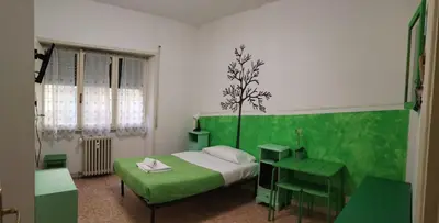 a bedroom with a bed and a green wall at Next Stop Roma Affittacamere Casilino in Rome