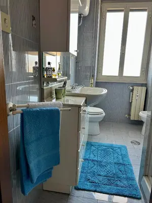 a bathroom with a sink and a toilet and a blue towel at Casa vacanze Morabito in Rome