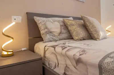 a bedroom with a bed with pillows and a lamp at A Casa di Giò in Rome