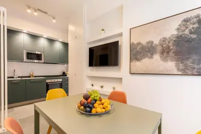 a kitchen with a table with a bowl of fruit on it at Hostly-San Paolo Charme Apartment in Rome