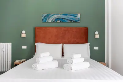 a bed with four towels stacked on top of it at Hostly-San Paolo Charme Apartment in Rome