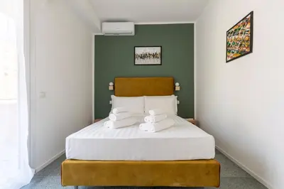 a bedroom with a large bed with white sheets at Hostly-San Paolo Charme Apartment in Rome