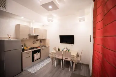 a kitchen with a table with chairs and a refrigerator at Monteverde Charme -ROMA- in Rome