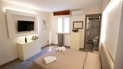 a white room with a bed and a television at Monteverde Suite -ROMA- in Rome