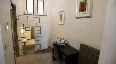 a room with a table with flowers on a wall at Monteverde Suite -ROMA- in Rome