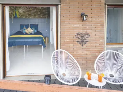 two white chairs on a patio with a bed in a window at TraStella, Trastevere di charme, balcone & hammam in Rome