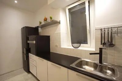 a kitchen with a sink and a black refrigerator at Art & Music Holiday Home in Rome