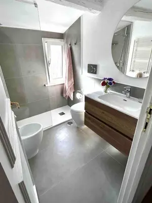 a bathroom with a sink and a toilet and a mirror at Panoramic Terrace Trastevere Apartment Amazing view in Rome