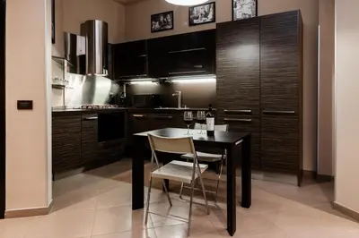a kitchen with a black table and chairs at Andy Home in Rome