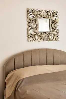 a mirror on a wall above a bed at Geppy Vacation home near Saint Peter Basilica in Rome