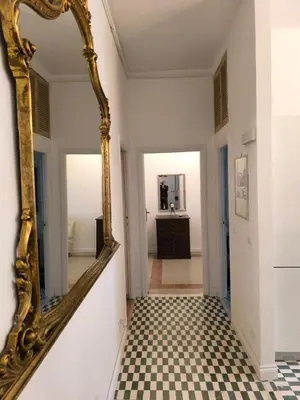 a hallway with a mirror and a checkered floor at Apartment Sora Marcella, Testaccio in Rome