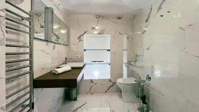 a bathroom with white marble walls and a toilet at Domus Jana 30 in Rome