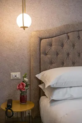 a bedroom with a bed and a table with a vase of roses at Roma suite hotel in Rome