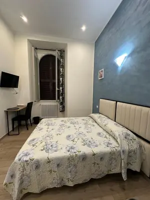 a bedroom with a bed with a blue wall at Marcelina Holidays in Rome