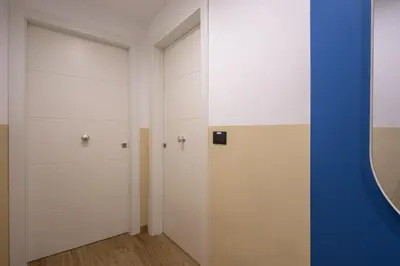 a closet with white cabinets and a blue wall at Yasmine Luxury Apartment in San Giovanni in Rome