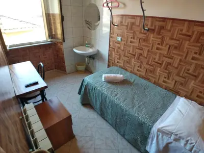 a small bedroom with a bed and a sink at Cressy in Rome