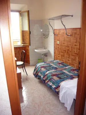 a bedroom with a bed and a bathroom with a sink at Cressy in Rome