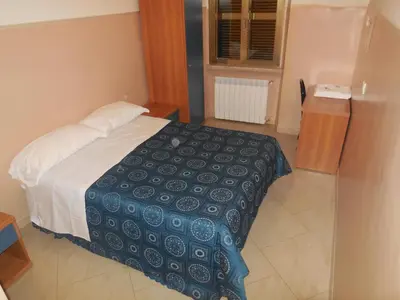 a bedroom with a bed with a blue and white blanket at Cressy in Rome