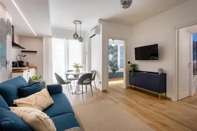 a living room with a blue couch and a table at Aida Luxury Apartment in San Giovanni in Rome