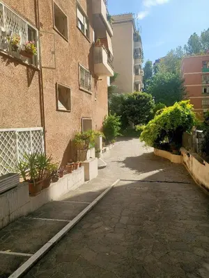 an empty street next to a building with potted plants at CasaCoco con posto auto e 2 bagni in Rome
