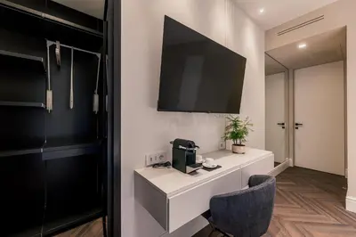 a room with a desk and a tv on the wall at Exclusive Domus Gaudia in Rome