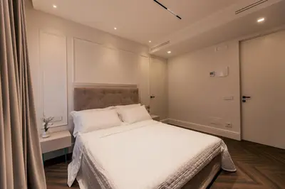 a bedroom with a large bed with white sheets at Exclusive Domus Gaudia in Rome