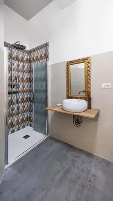 a bathroom with a sink and a shower with a mirror at DolceVite - Fontana Di Trevi in Rome
