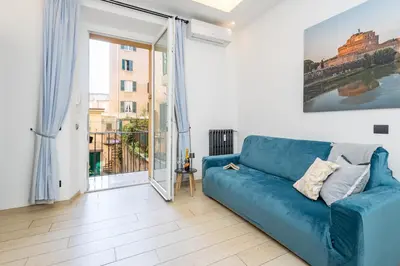 a blue couch in a living room with a large window at Colosseo Apartment holiday Venus Appartamento al Colosseo a Monti in Rome