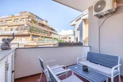 a blue bench and chairs on a balcony with a building at Vatican Hills Apartment in Rome