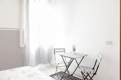 a dining room with a table and two chairs at Domus Merulana Bed and Breakfast in Rome