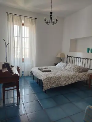 a bedroom with a bed and a table and a piano at Appartamento Delle Grazie in Rome
