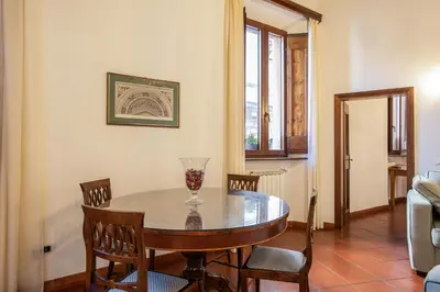 a dining room table with chairs and a vase on it at Santa Caterina by the Pantheon - 2BR in Rome