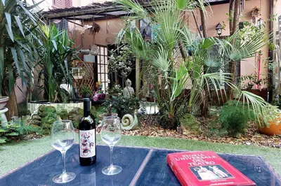 a bottle of wine and two glasses on a table at Garden Corner Pigneto apartment Rome in Rome