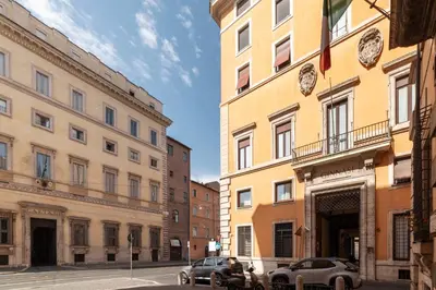 a street with two buildings and two cars parked in front at Torre Argentina - Charme Holidays in Rome