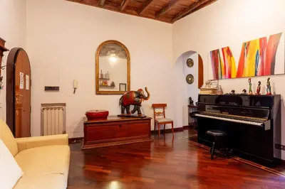 a living room with a piano and a mirror at Trastevere Enchanting Apartment in Rome