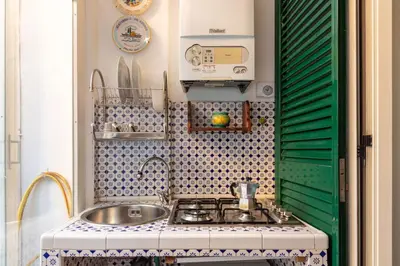 a small kitchen with a sink and a stove at Trastevere Enchanting Apartment in Rome