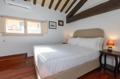 a white bedroom with a bed and a window at Pantheon Rondanini Luxury Penthouse in Rome