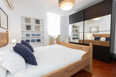 a bedroom with a large white bed with blue pillows at Pantheon Rondanini Luxury Penthouse in Rome