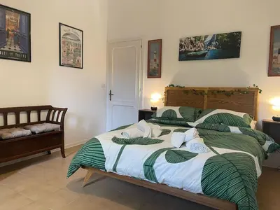 a bedroom with a large bed with green and white sheets at Gemelli Roma House Apartment in Rome