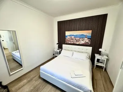 a bedroom with a white bed and a mirror at Mellini Escape in Rome